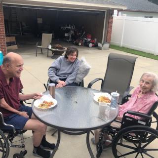 A group of people enjoying a meal together on a patio.