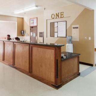 A reception area with a wooden counter and a water cooler.