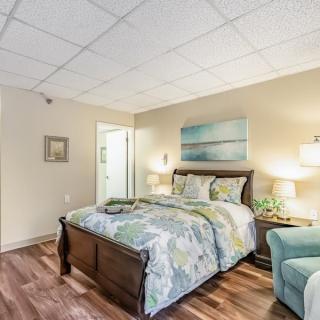 A cozy bedroom with a neatly made bed, elegant furniture, and soft lighting creating a welcoming atmosphere.