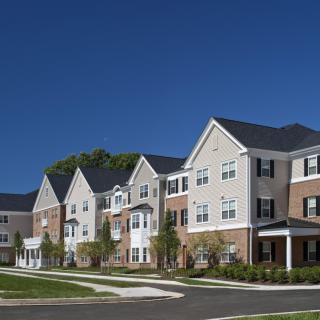 A modern suburban residential housing complex under a clear blue sky.