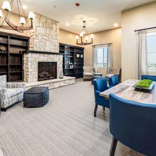 A cozy and modern living room featuring a fireplace, bookshelves, and comfortable seating.