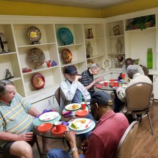 A group of seniors enjoying a meal together in a cozy indoor setting.