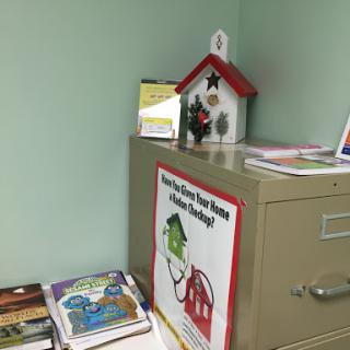 A cozy corner featuring books, a filing cabinet, and home-themed decorations.