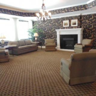 A cozy living room with a fireplace, sofas, and a chandelier.