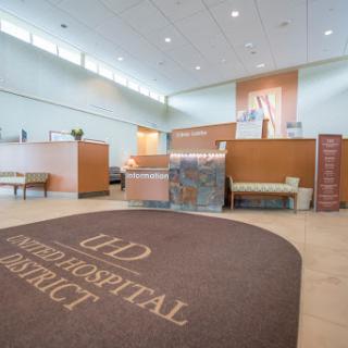 A welcoming lobby of a hospital with a reception area and comfortable seating.