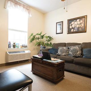 A cozy living room with a couch, coffee table, and decorative wall art.