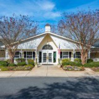 A charming residential building with a landscaped front and clear blue skies.