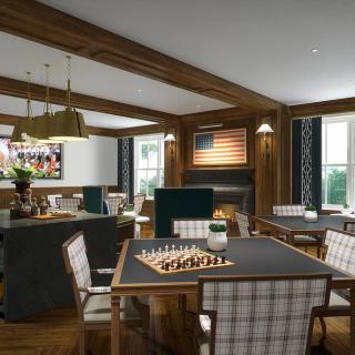 A cozy dining and game room featuring a fireplace, chess set on the table, and checkered chairs.