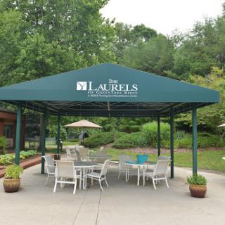 A serene outdoor pavilion with seating, surrounded by lush greenery.