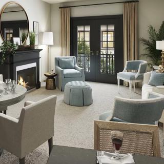 A cozy and elegantly designed living room featuring a fireplace and ample seating.