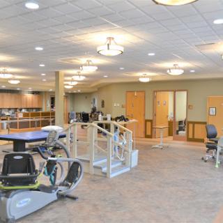 A well-equipped rehabilitation center designed for physical therapy, featuring various exercise equipment and a spacious layout.