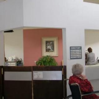 A waiting area with a reception desk and people seated.