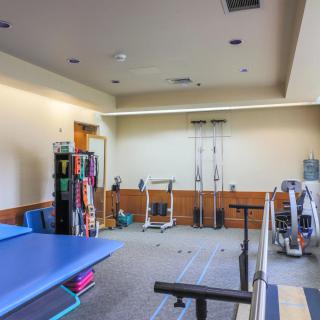 A physical therapy room equipped with various exercise and rehabilitation tools.
