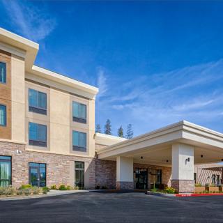 A modern hotel building with a welcoming entrance under clear blue skies.