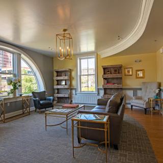 A cozy living room featuring modern furniture, a well-lit atmosphere, and a bookshelf filled with books.