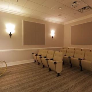 A small theater room with a row of comfortable seating and soft lighting.