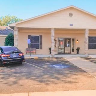 A single-story building with a parking lot and wheelchair-accessible entrance.