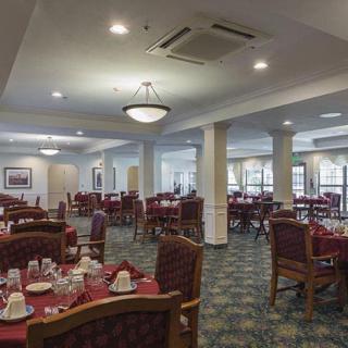 An elegantly set dining room with tables and chairs prepared for guests.