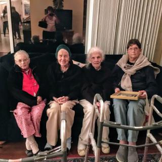 A group of elderly individuals seated together indoors.