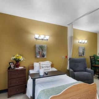 A cozy bedroom with a bed, armchair, and decorative elements.