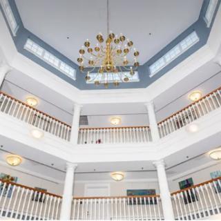 An elegant interior view showcasing a multi-level atrium with a stunning chandelier and stylish railings.