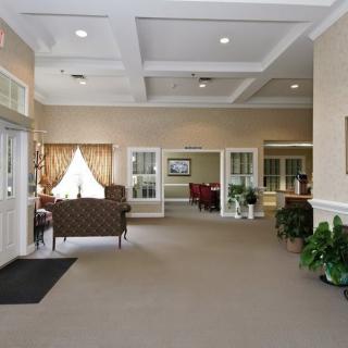 A spacious and well-lit lobby area with seating and decorative plants.