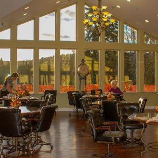 A cozy restaurant interior with large windows providing ample natural light.