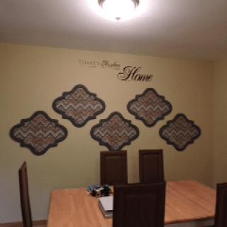 A dining area featuring a wooden table, chairs, and stylish wall decor.