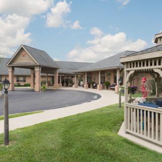 A well-maintained building with a gazebo, lush green lawn, and a clear blue sky.