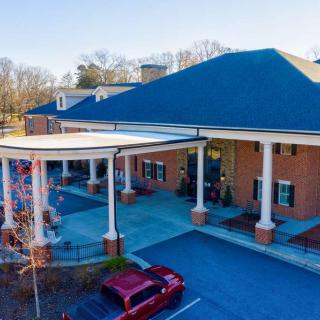 A building entrance with columns and a parking area for vehicles.