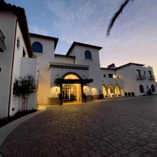 A Mediterranean-style building entrance illuminated during the evening.
