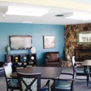 A cozy living room with a table and chairs, featuring a fireplace and decorative elements.
