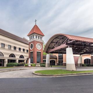 A modern building with a distinctive tower and arched entrance.