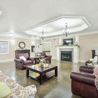 A cozy and well-decorated living room with leather sofas, a central coffee table, and a fireplace.