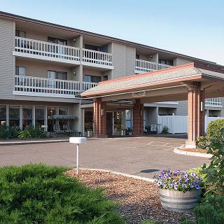 The exterior view of a multi-story hotel with a covered entrance and balconies.