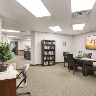 Spacious office interior with a conference area and bookshelf.