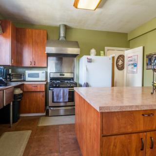 A cozy kitchen featuring wooden cabinets, a kitchen island, and stainless steel appliances.