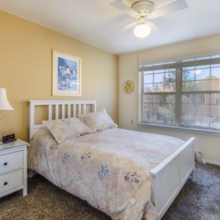A cozy bedroom with a large window and neutral color scheme.