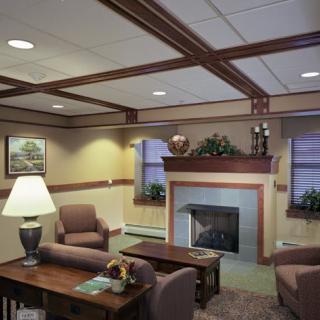 A cozy living room with traditional decor, featuring comfortable seating and a central fireplace.