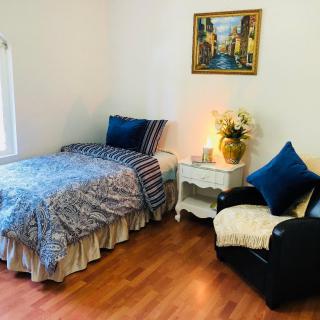 Cozy bedroom with a single bed, armchair, and decorative elements.