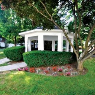 A charming gazebo surrounded by lush greenery and well-maintained landscaping.