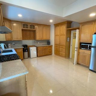 A spacious kitchen with wooden cabinets and stainless steel appliances.