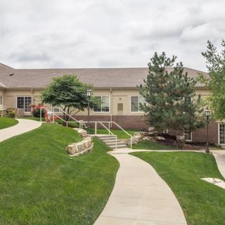 A scenic view of a building with landscaped surroundings and a winding walkway.