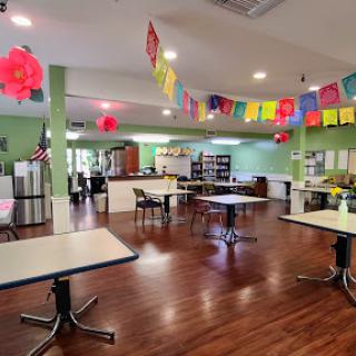 A welcoming dining area featuring green walls, decorative banners, and ample seating.