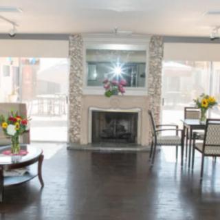 A bright living room with a fireplace, decorated with flowers and modern furniture.