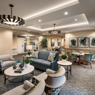 A modern and elegantly furnished living room with comfortable seating, stylish lighting, and decorative artwork.