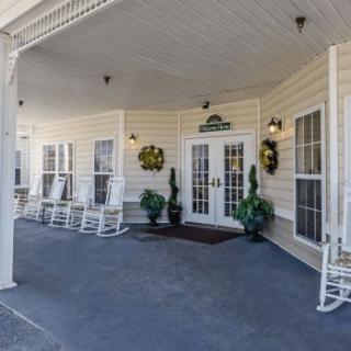 A welcoming porch with rocking chairs and decorative plants at the entrance.