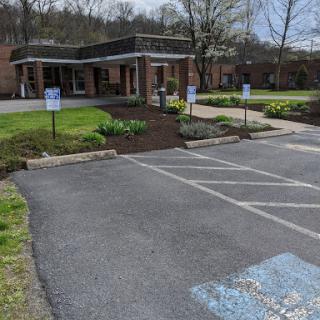 A view of a well-maintained building with a parking lot and landscaped garden.