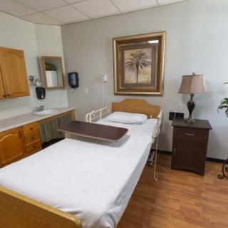 A clean and well-organized hospital room with a single bed and cozy decor.
