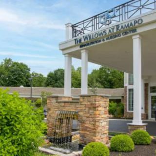 The entrance of a building with columns and landscaping.
